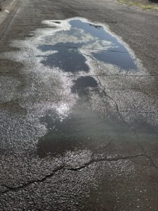 [Clouds reflected in rain puddle]